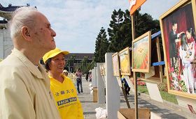排字的四周同时展出“大法弟子证实法摄影作品展”,市民认真地观看作品集,及听取法轮功学员的解说