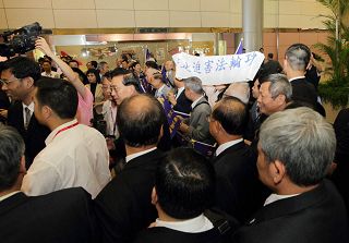 黄华华所带领的广东团一出海关,即面对法轮功学员在桃园机场大厅打出“法轮大法 真善忍”、“停止迫害法轮功”等横幅。