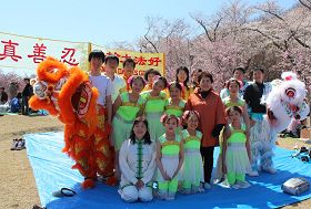 '舞台表演结束后,Kito理事长夫人愉快地和法轮功学员们合影留念'