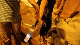 一名穿间条衫的女凶徒一度从另一名亲共团伙徒众手上接过锯刀,准备趋前恐吓记者。