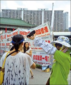 穿绿衣者系亲共团伙成员,举高音量喇叭干扰法轮功学员