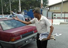 '马来西亚法轮功学员前往新纪元学院递交公开信,遭到四个华教界人士的野蛮对待。图为其中一人抢走和撕毁资料后,还不断对着法轮功学员谩骂。'