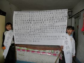 '贾彬的孩子身披“我要妈妈,我要吃饭”的条幅'