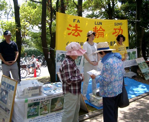 图2:学员们在第十八届稻泽夏季活动节展位上向市民介绍法轮功