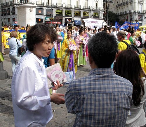 图5-6：在太阳门广场法轮功反迫害集会现场，法轮功学员向驻足观看的华人讲真相劝三<span