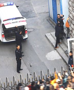 图2:于溟在进入法庭前,面带微笑向围观人群挥手并高喊