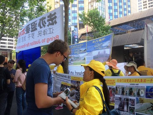 中共代表团入住的酒店外,法轮功学员举横幅,讲真相