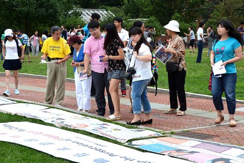许多游客不但认真阅读讲述法轮功真相的图片,并与学员攀谈了解真相。