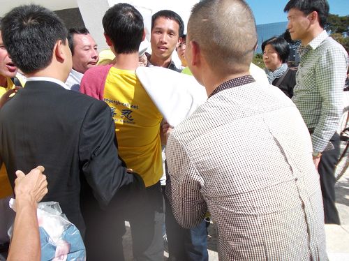 图3:中共指示的凶徒于公共场合围殴法轮功学员,抢走横幅