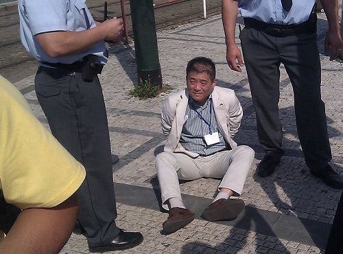 图:因对法轮功学员施暴而被捷克警察铐住的中使馆官员