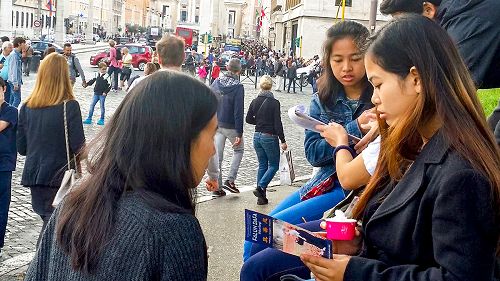 图1-3:圣天使堡旁的广场上,法轮功学员在和民众交谈,传递真相
