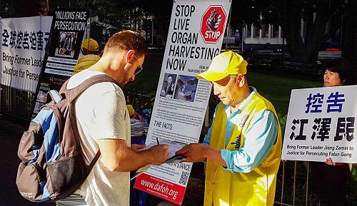 图7-8:主流社会民众在下班路上驻足了法轮功解真相,签名反迫害。