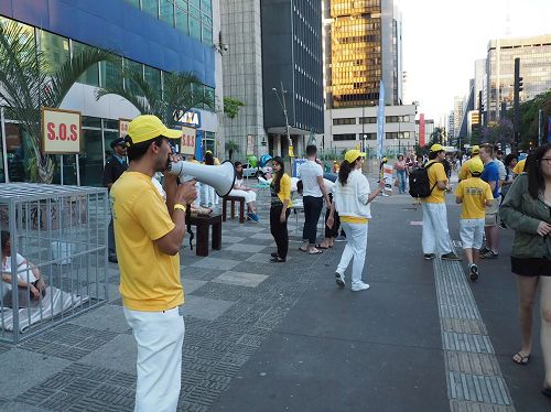 '图4:法轮功学员告诉人们中共迫害法轮功的真相。'