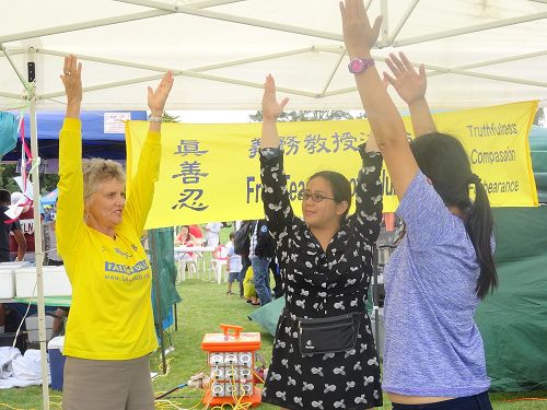 图3:来自菲律宾的米歇尔(Michelle)女士和来自越南的楠姆(Nam)女士主动向西人法轮功学员朱迪•莎士比亚(Judy Shakespeare)女士学习法轮功功法