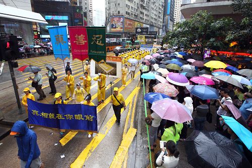 图6-12：法轮功学员希望民众了解真相，在游行队伍中打出了揭迫害、唤良知、启善念、劝三<span style='max-width:0px!important;margin-left:-4px;color:#eee!important;'>:</span>退<span style='max-width:0px!important;margin-left:-4px;color:#eee!important;'>.</span>等横幅。