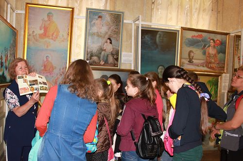 图1:法轮功学员在乌克兰哈尔科夫市举办“真善忍”国际美展,传播法轮功真相。图位,参观者倾听画展导览的解说。