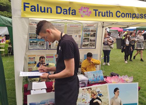 图6:英国小伙卡勒姆(Callum)签名支持法轮功学员反迫害。