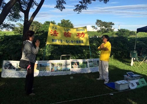 图3:后藤女士(左)在稻泽夏季活动节展位上当场学炼法轮功