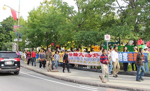 图6：总督府门前，大陆旅游团经过法轮功的打横幅队伍，有人现场做了三<span