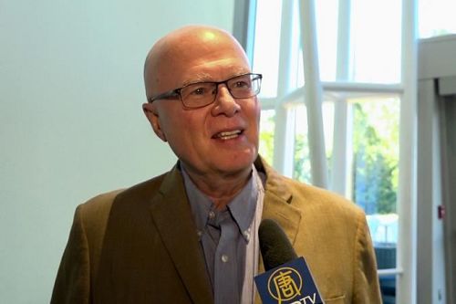 '图12:华府一家理疗机构CEO丹尼斯(Bill Dennis)和太太聆听了神韵交响乐团的演出后,感受到身心被治愈,所有忧虑都消失无踪。'