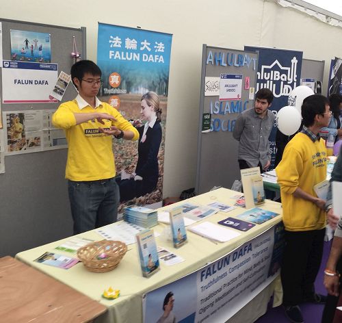 '图1:英国青年学员在英国金斯顿大学(Kingston university)大型室内年度学生社团迎新会上弘法'