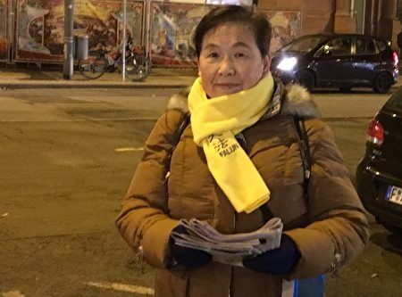 '图4:法轮功学员文女士在法兰克福街头给中国游客发关于法轮功的真相报纸。'