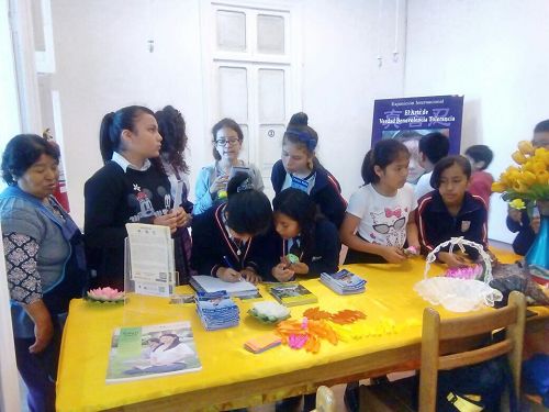 '图7:Colegio Sagrado Corazon学生观看画展后争相在留言簿上留言。'