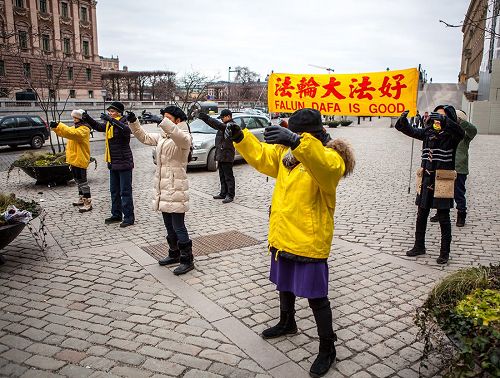 '图1,瑞典法轮功学员在钱币广场上举办法轮大法信息日活动'