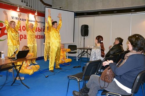 '图1:展会期间法轮功学员向民众介绍了法轮功并展示了五套功法动作'
