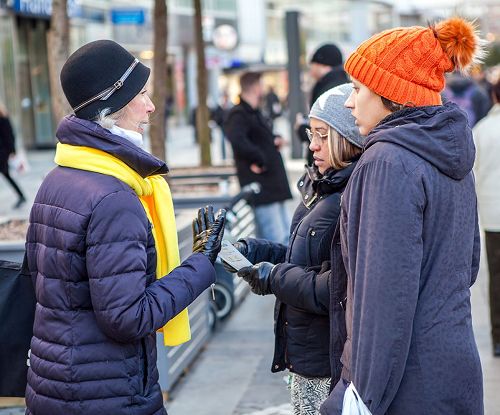 '图6:法轮功学员面对面向过往路人讲述法轮功的真相'