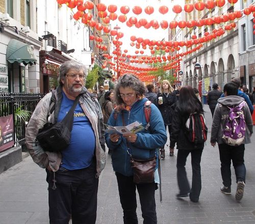 '图13:二零一七年四月二十二日,上世纪九十年代听说过法轮功的英国女士珍妮和丈夫在伦敦唐人街上碰到纪念“四·二五”法轮功学员和平上访十八周年的游行队伍'
