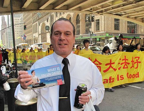 '图12:在一家高档宾馆工作的乔治站在路边认真观看法轮功纽约大游行'