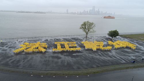 图1:庆祝“世界法轮大法日”,法轮功学员冒雨排出“法正乾坤” 四个大字。