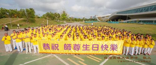'图1:庆祝五一三世界法轮大法日暨法轮功创始人李洪志大师生日,高雄部份法轮功学员聚集在高雄卫武营、台湾最大国家剧院门前广场合影,齐声“恭祝师父生日快乐!”'