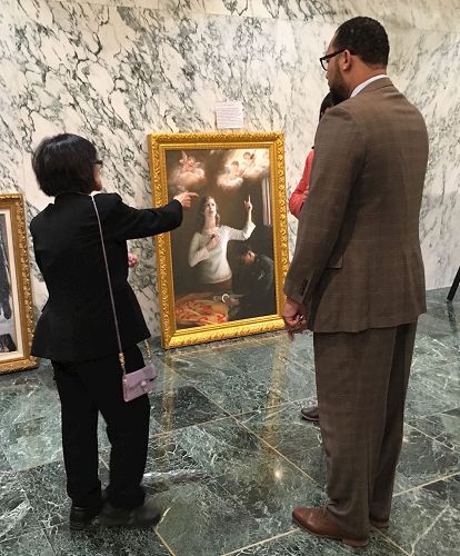 '图8:法轮功学员给到州首府开会的人介绍画展。'