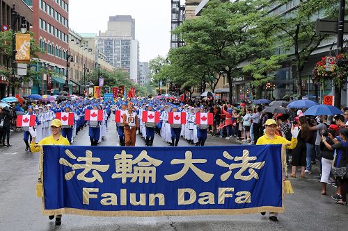 '法轮大法天国乐团,和旌旗、炼功队伍的法轮功学员共250多人应邀参加了蒙特利尔7月1日举办的加拿大国庆游行,受到东、西方观众盛赞。'