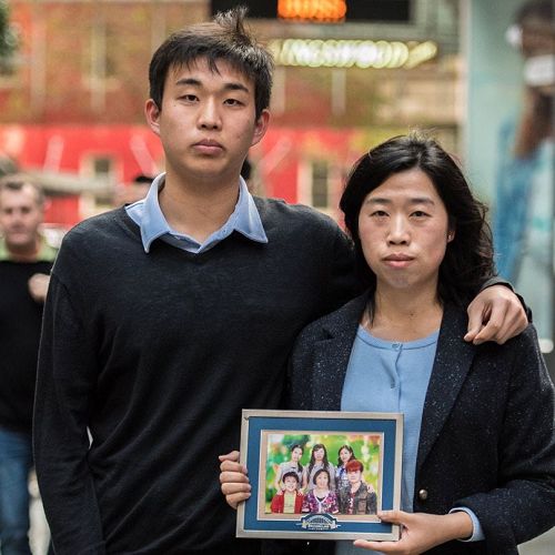 '图1:法轮功学员刘玲(右)拿着全家福照片和侄子贾明真'