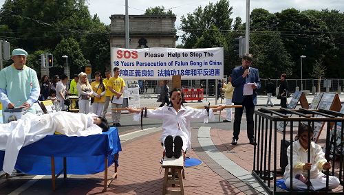 '图五:法轮功学员以模拟演示揭露中共地酷刑迫害和活摘器官。'
