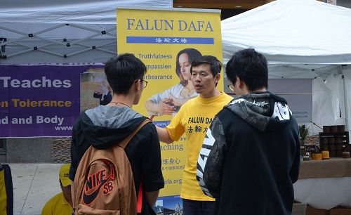 '图5:大陆留学生驻足了解法轮功真相'