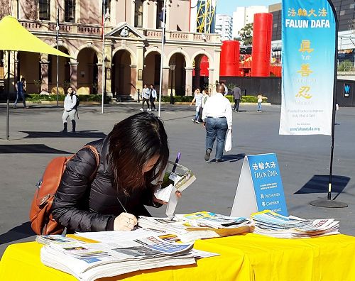 '图6:杰西卡(Jessica Jenguyen)径直走到签名支持反迫害摊位上签名'