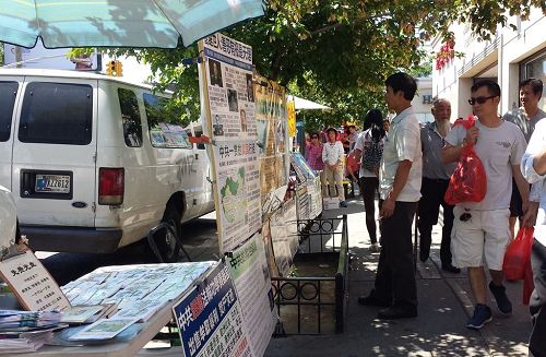 '图3~5:法轮功学员在布鲁克林“八大道”设立真相点,不少过往民众经过时阅读真相展板。'