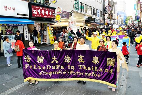 '图8~23:向市民和游客展现法轮大法的美好以及揭露中共对法轮功的迫害的大游行吸引许多民众驻足观看。'