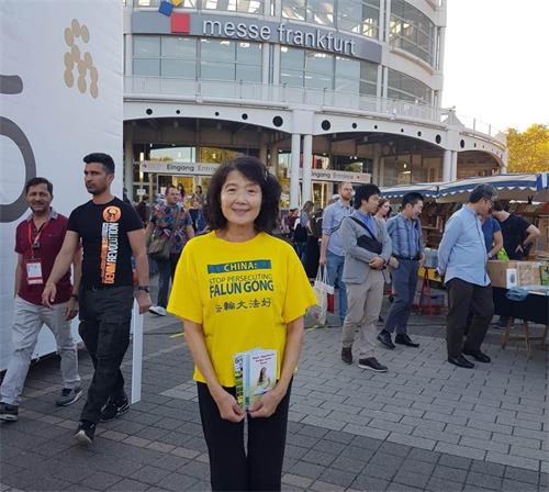 '图5：法轮功学员陈女士在书展期间给中国人讲真相，劝“三<span