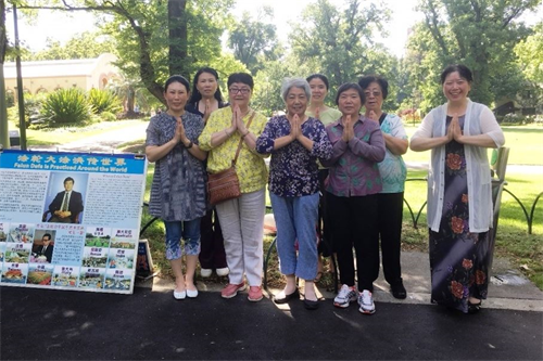 '图2:二零一八年十二月二十七日,墨尔本著名旅游景点费茨罗伊公园(Fitzroy Gardens)真相点的法轮功学员恭祝师尊新年好。'