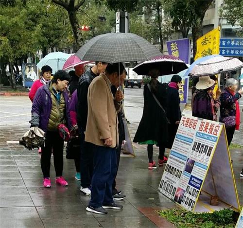 '图1~2:国父纪念馆前,大陆游客认真阅读法轮功真相展板'