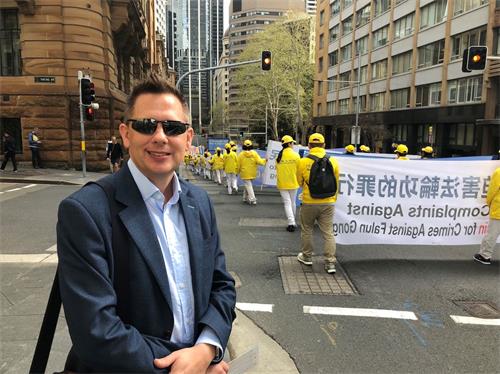 '图13:医生马克·盖塔斯?(Michael?Gathas)?在路边驻足非常仔细的欣赏游行队伍'