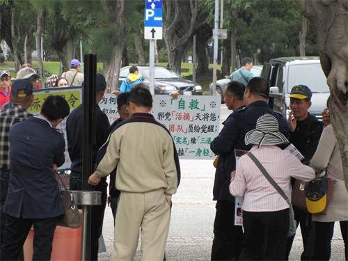 '图2:中国大陆游客观看法轮功真相展板,聆听学员讲真相。'