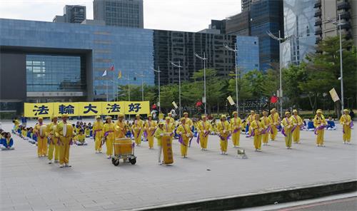 '图4:咚咚的鼓声,一身金黄装扮的腰鼓队,吸引过往行人的目光。'