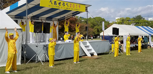 '图1:二零一九年十月二十七日,法轮功学员在广岛和平与友爱国际交流节的舞台上演示法轮功五套功法动作。'
