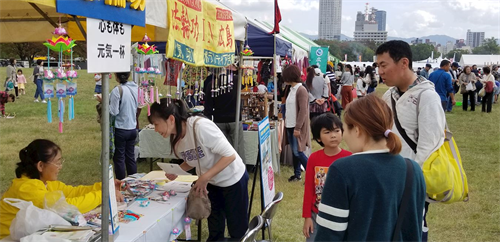 '图4:法轮功学员在和平与友爱国际交流节上设立了展位,不少民众驻足了解法轮功。'